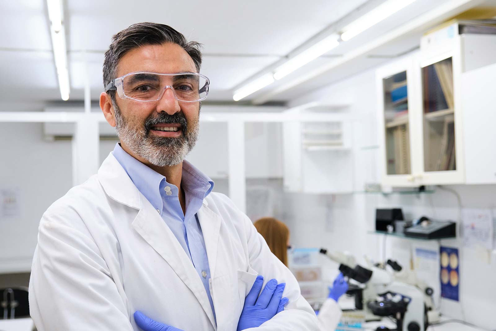Portrait of medical scientist wearing goggles standing inside of a lab