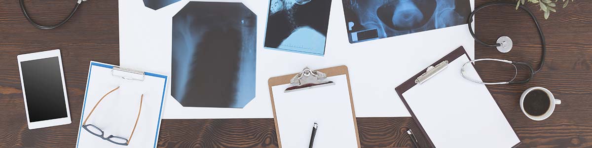 Overhead view of desk with scattered clipboards and smart devices