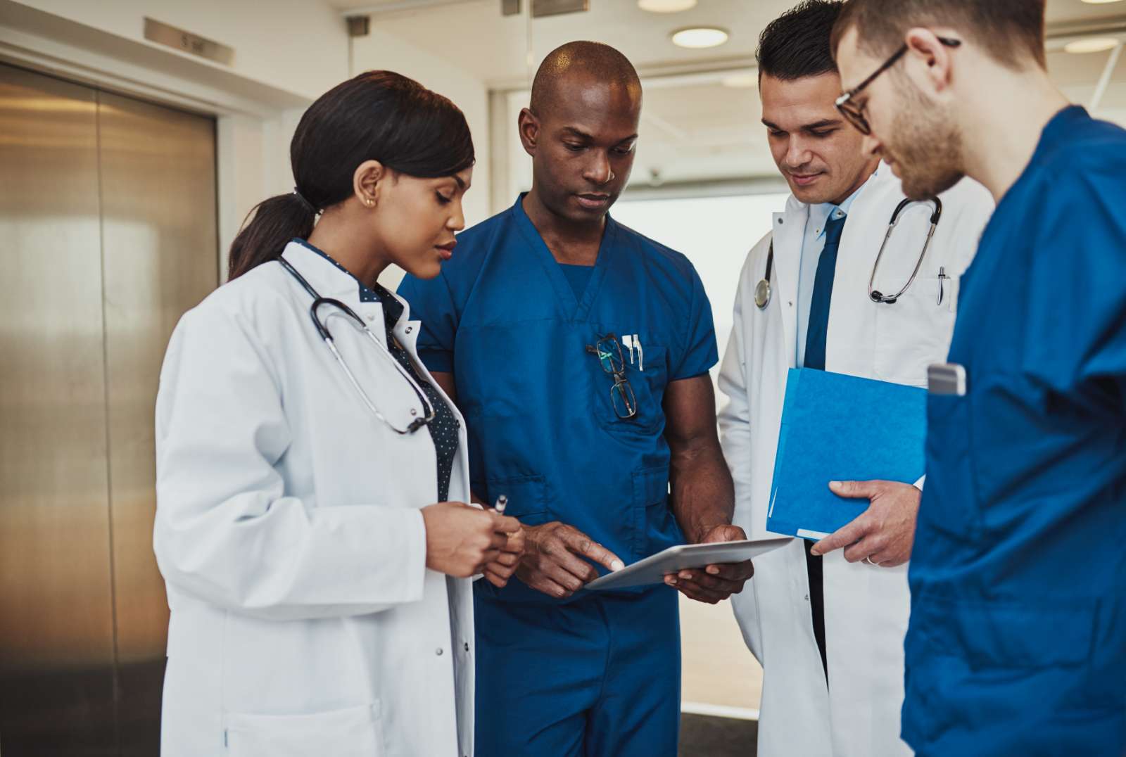 multiracial team of doctors discussing a patient